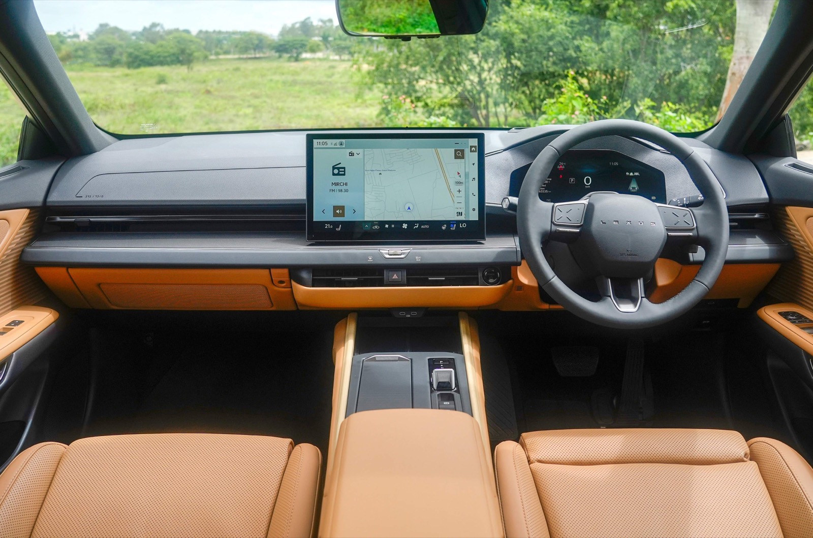 The new Lexus ES 350h dashboard: a 14-inch screen, a blank strip of veneer where the climate switches sleep until a hand approaches, and a steering wheel with the word LEXUS where the emblem used to be
